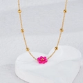 Close-up of golden beaded chain necklace featuring a magenta woven flower pendant - Gold - Rose Red Flower Necklace