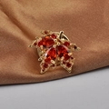 Elegante spilla a foglia d'acero dorata con pietre preziose rosse su seta marrone - Piccola foglia di acero rossa