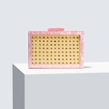 Pink marble acrylic clutch bag with woven yellow rattan detail on white pedestal - Pink