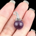 12mm amethyst wizard hat pendant with silver metal cap held against a black background - Amethyst