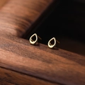 Elegant gold-plated S999 silver hollow teardrop stud earrings on a textured wood surface - 990 Silver / Gold