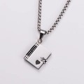 Macro view of silver stainless steel book-shaped locket with heart-shaped cutout - Black