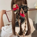 Detailed view of a large vintage bow hair clip with chain print on a model's hair - Black Chain Print Ribbon