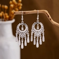 Ethnic silver-style earrings with hollow patterns and tassel pendants on a wooden branch - Silver Hollow Ring Tassel Style 2(E2875-34)