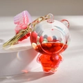 Detail view of transparent liquid bear keychain with colorful beads and golden metal ring - Gradient Strap + Bear / Red