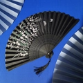 Classical black bamboo folding fan featuring white floral and butterfly patterns with silk tassel - Black Floral Butterfly