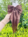 Macro detail of brown satin bow hair clip with long ribbon tails on green background - Scarf Bow / Brown