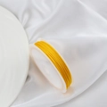 Roll of bright yellow braided cord for jewelry making on white satin background - 10m / Gold