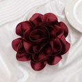Dettaglio ravvicinato della spilla a rosa in raso rosso vino con petali di seta - Borgogna