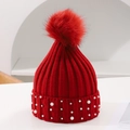 Detailed view of red knit hat with plush pompom and pearl accents on the brim - One Size / Burgundy