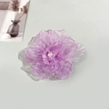 Dettaglio di un fermaglio per capelli a camelia in organza viola con petali ondulati - Viola