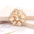 Macro shot of marquise crystal flower accessory with champagne gems on golden base - Champagne