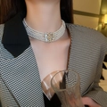 Détail d'un collier de perles à quatre rangs avec boucle fleurie dorée sertie de diamants - Four Row Pearl Rhinestone Clasp Necklace / Or-Blanc