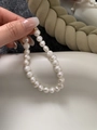 Vista macro di perle d'acqua dolce barocche con chiusura dorata e catena di estensione - Bracciale in perle d'acqua dolce