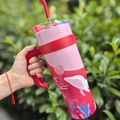 Pink and red 40oz insulated travel mug with whale print and handle held in hand - 1250ml / Pink Whale