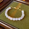 Dettagli del bracciale con perle di cristallo rosa, filo dorato e pendente a foglia fine - Rosa