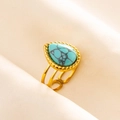 Macro shot of adjustable gold-plated ring featuring a teardrop turquoise with beaded edges - Gold Base Light Blue Stone (J550-G-LB)