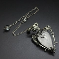 Detailed view of silver skull pendulum pendant with clear crystal and ornate engravings - Clear Quartz + Pendulum Chain