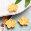 Detailed macro view of yellow resin cherry blossoms with pink centers for DIY crafts - Yellow