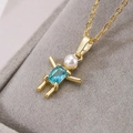 Macro shot of gold-plated robot pendant with blue zircon body and pearl head on grey velvet - Blue Gemstone Boy Style / Gold Blue (23040)