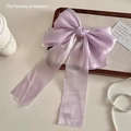 Détail d'un grand nœud à cheveux en organza violet placé dans un plateau chic - Violet