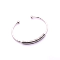 Bracciale rigido aperto in acciaio argento lucido con dettagli a molla e terminali a sfera - Color Acciaio
