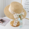 Detail of raffia straw hat with white lace ribbon and blue tulip pendant on wood stand - Khaki With Blue Tulip