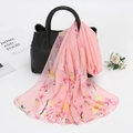 Detail of pink floral chiffon scarf elegantly draped over a black leather handbag - 150cm / Pink