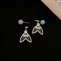 Detalle de pendiente de lujo con circonita y perla irisada sobre fondo negro - Pendientes de Cola de Pez Dorados (Pin de Plata 925)