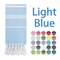 Detail of light blue striped Turkish towel with fringe and colorful fabric swatches - Light Blue