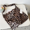 Detailed close-up of brown leopard print canvas tote bag with books and MISS hangtag - Camel Leopard