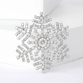 Macro shot of silver snowflake brooch with sparkling rhinestones and crystal center - Silver