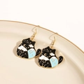 Detail of cute black cat earrings with cloud and moon charms on a ceramic plate - Star Moon Cloud Black Cat