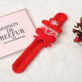 Detail eines roten Weihnachts-Schneemann-Klapparmbands auf weißem Kunstfell mit Deko - Schneemann