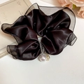 Close-up of black satin and organza scrunchie with elegant pearl and rhinestone charms - Black