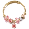 Gold-plated beaded bracelet featuring pink enamel flowers and faceted crystal charms - Daisy
