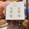 Silver 925 tassel earrings with bow design and pearls shown in a lifestyle view - Silver Pearl Bowknot Full Zircon Tassel (E0365)