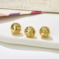 Close-up of golden hollow spheres with embossed vintage patterns for DIY jewelry - Style 23