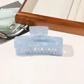 Close-up of large light blue iridescent PVC hair claw clip on a wooden tray - PVC 10.5cm Rectangular - Iridescent Blue