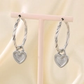 Macro view of silver heart hoop earrings with grey enamel on a soft silk background - Twisted Hoop Heart Dangle Earrings / Full Steel Color