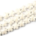 Vista macro di perle di ceramica a fiori bianchi per gioielli fatti a mano e accessori fai-da-te - Bianco