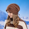 Bonnet en tricot marron avec rayures à paillettes et logo sur fond de montagne enneigée - café