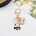 Close-up of a panda keychain with gold lobster clasp and panda charm on white background - Panda Eating Bamboo with Panda Tag