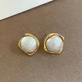 Gros plan sur des boucles d'oreilles dorées avec perles baroques et monture carrée organique - Style Rond à Bordure Dorée Vintage Français (7)