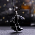 Detail of a crescent moon pendant with black stone and silver wire tree of life wrap - Obsidian