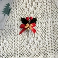 Détail d'un cake topper de Noël avec baies rouges, feuilles de houx et clochette - Style de Feuille A