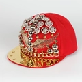 Detail of red hip-hop hat with golden wings, studs, and metal chain on flat brim - Adjustable / Red