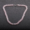 Macro detail of natural pink stone beaded necklace with silver lobster clasp on black background - Rose Quartz Necklace