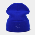 Detail of royal blue ribbed knit beanie featuring white sun embroidery on the folded cuff - Blue