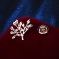 Broche branche dorée avec motif de feuilles sur fond d'affichage en velours rouge - Petit Arbre Doré
